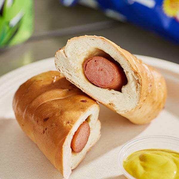 A hot dog in a bread roll with a hot dog in a bread roll in the background.