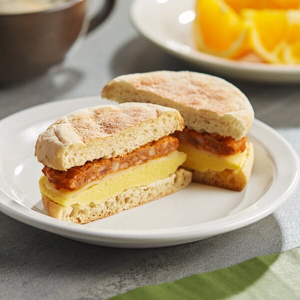 A Clara's Kitchen Chorizo breakfast sandwich cut in half on a plate.