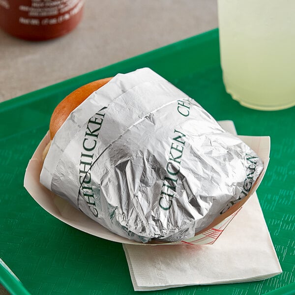 A tray with a chicken sandwich wrapped in Bagcraft foil.