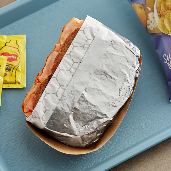 A Bagcraft honeycomb foil wrapped sandwich on a tray.