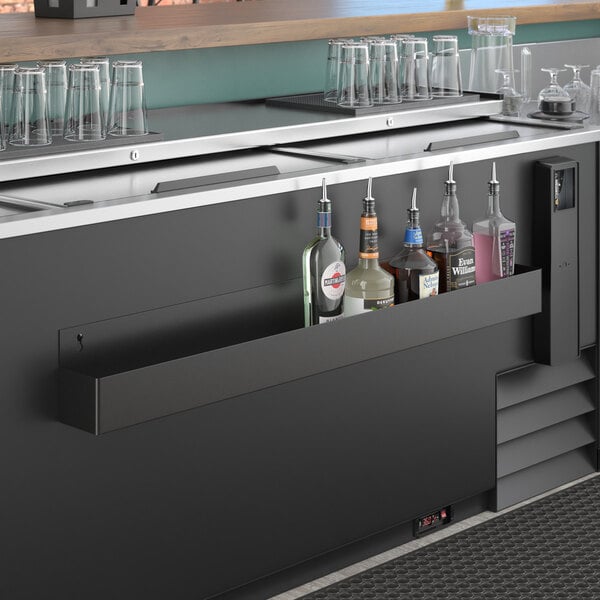 A Steelton single tier speed rail on a bar with bottles and glasses.