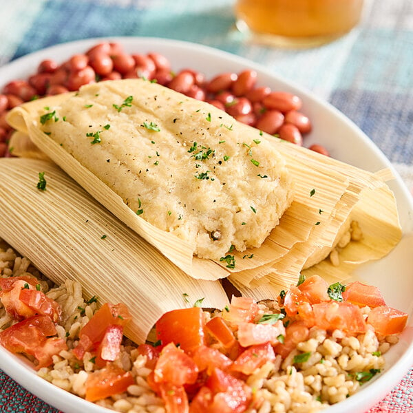 A plate of Tucson Foods Green Chile and Chicken Tamales with beans and rice.