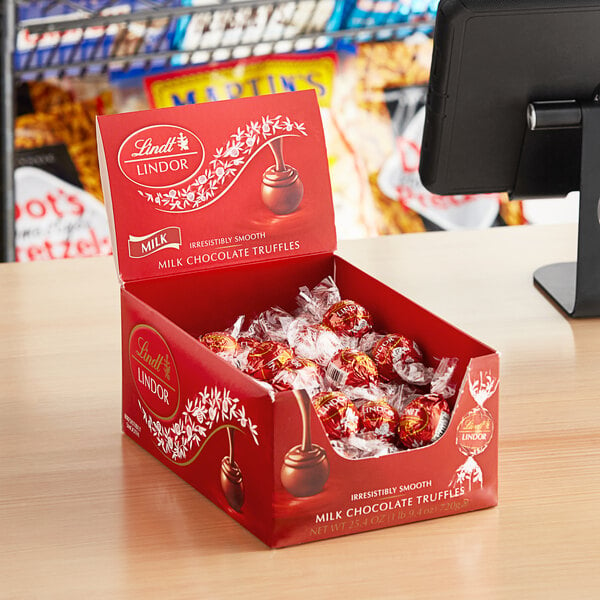 A case of Lindt Lindor milk chocolate truffles on a counter.