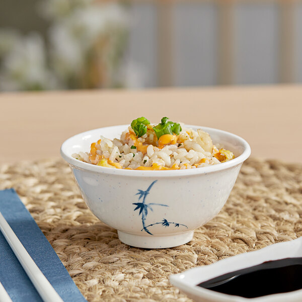 A bowl of rice with vegetables and sauce in an Acopa Bambu Biru melamine rice bowl with chopsticks.