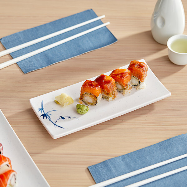 A rectangular white plate with sushi on it.