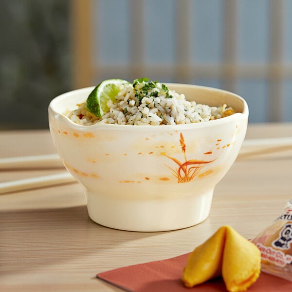 A bowl of rice with limes and a chopstick in an Acopa Brassia melamine bowl.