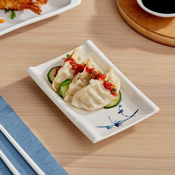 A rectangular Acopa Bambu Biru melamine plate with a meal on a table.