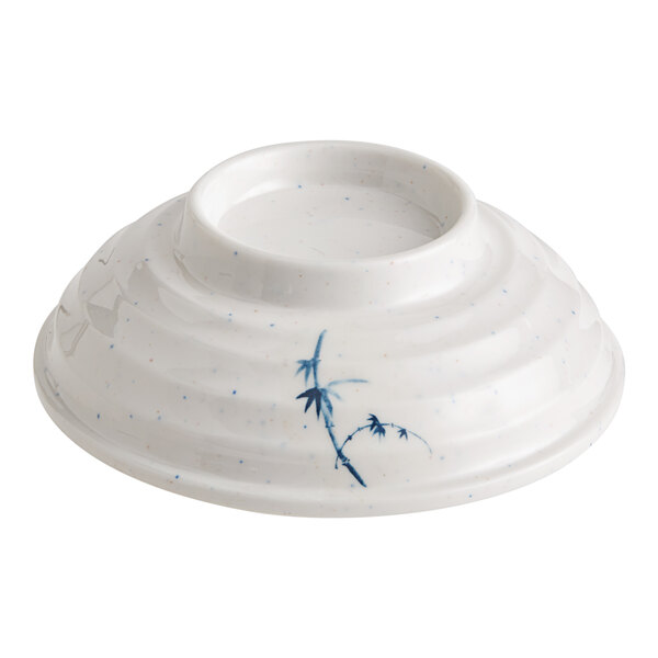 A white bowl with blue and white design on the lid.