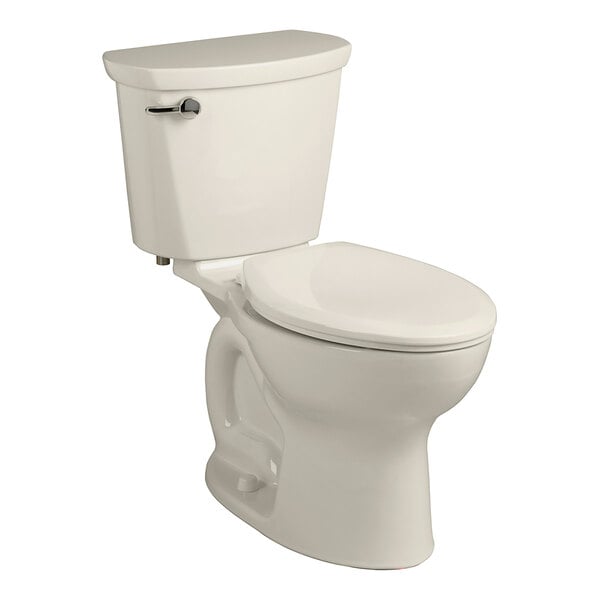 An American Standard linen vitreous china toilet with a silver handle and the seat down.