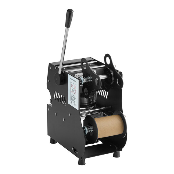 A black and silver Galaxy Manual Bubble Tea Sealing Machine with a roll of paper on top.