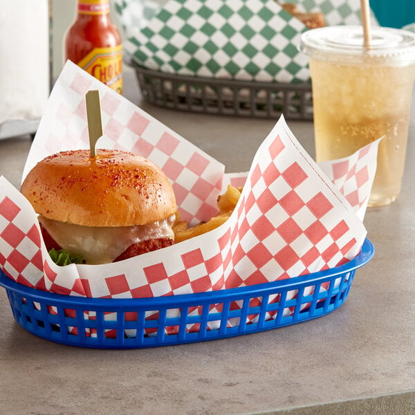 A basket with a burger and fries in red check deli paper.