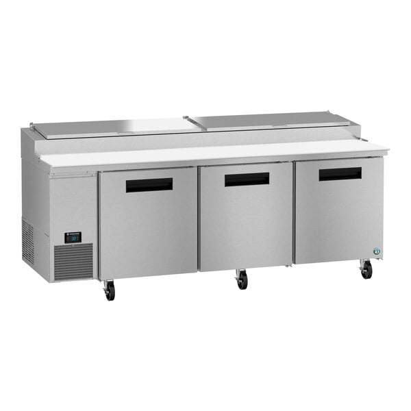 A stainless steel Hoshizaki refrigerated pizza prep table with three doors.