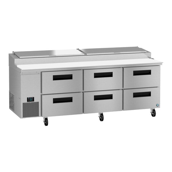 A Hoshizaki refrigerated pizza prep table with six drawers on a stainless steel counter.