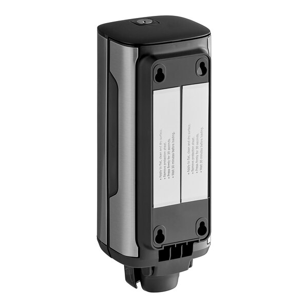 A close-up of a black and silver Tork wall-mount soap dispenser with two holes.