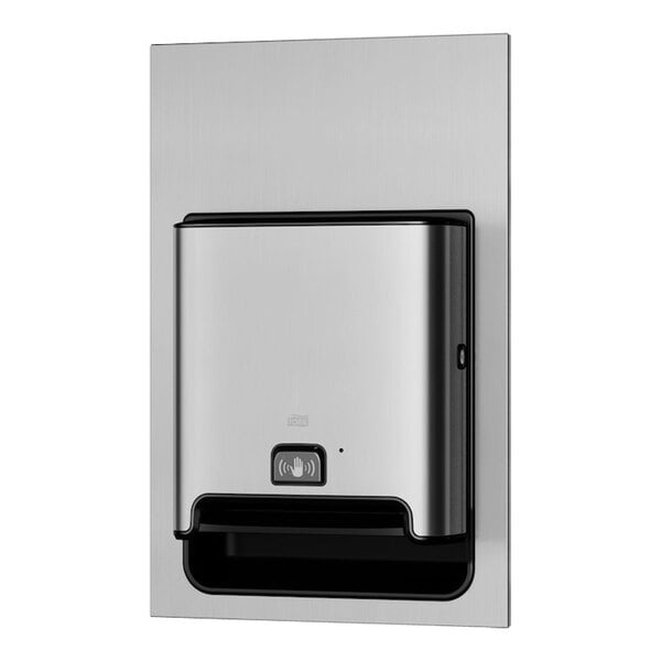 A Tork stainless steel recessed automatic paper towel dispenser on a wall.