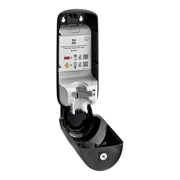 A close-up of a black Tork wall-mount automatic foam soap dispenser with a key and lid.