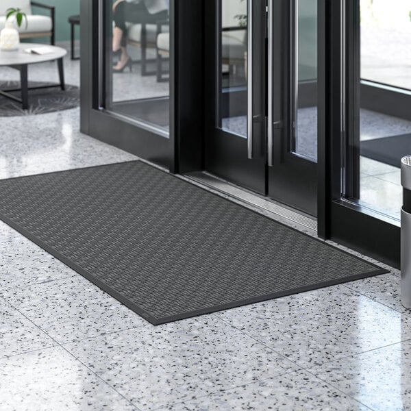 A black Lavex parquet entrance mat with a black border on a marble floor.
