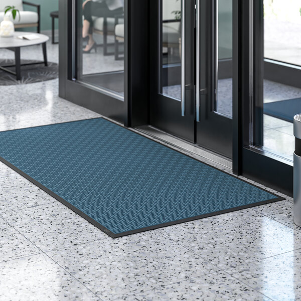 A blue Lavex parquet entrance mat on a floor.