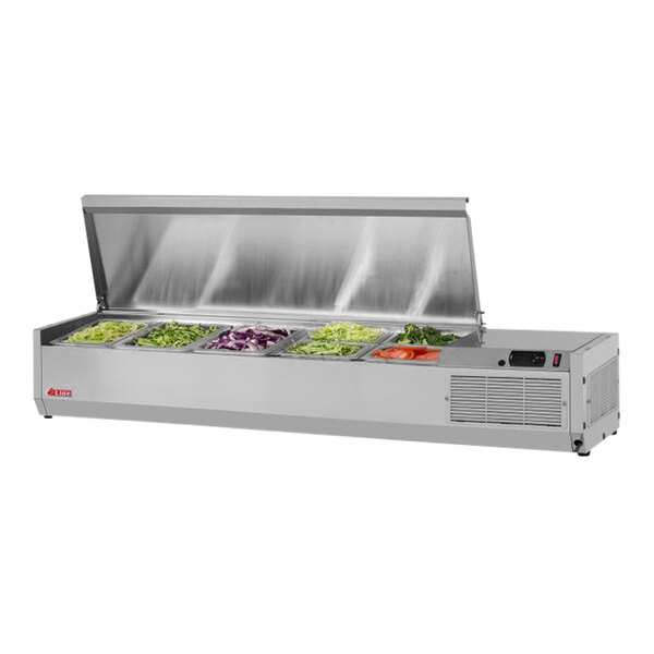 A stainless steel Turbo Air refrigerated countertop salad prep table with vegetables in food trays.
