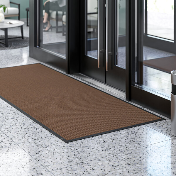 A brown Lavex waffle entrance mat on a white surface.