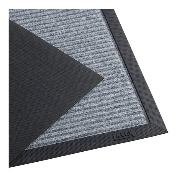 A close-up of a gray Lavex Needle Rib indoor entrance mat with a gray stripe.