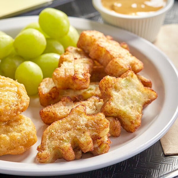 A plate of Dr. Praeger's Broccoli Littles with a bowl of sauce and grapes.