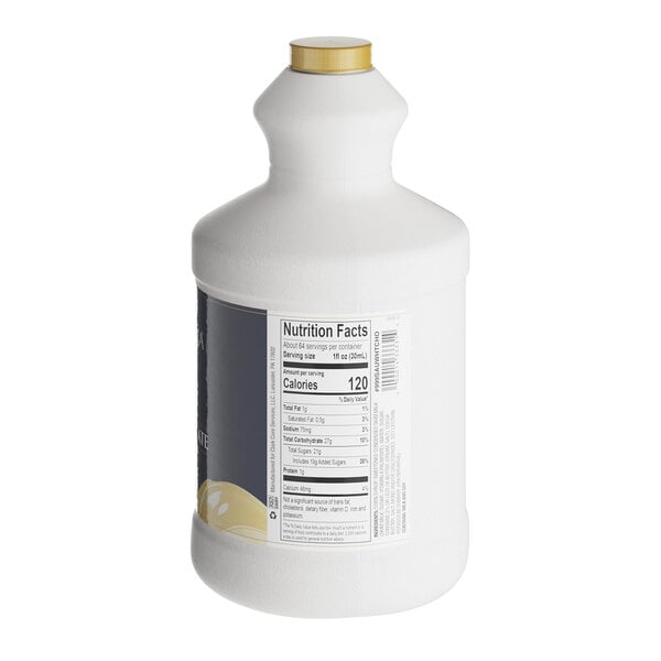 A white Capora bottle of white chocolate flavoring sauce with a label.