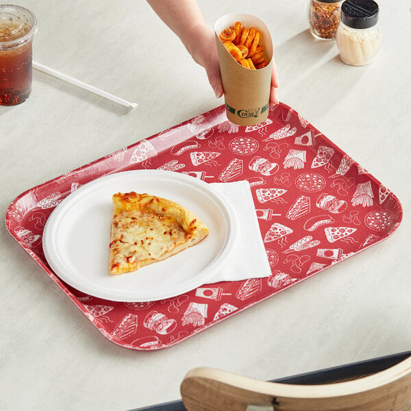 A hand holding a red Cambro tray with a slice of pizza, fries, and a paper cup.