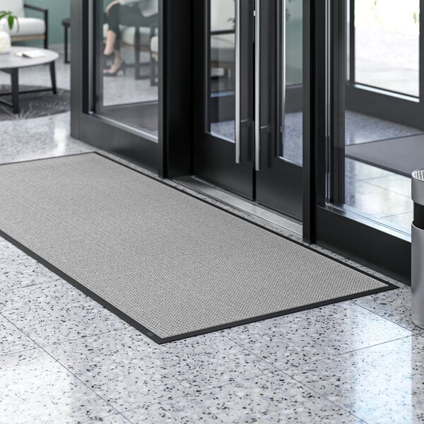 A large gray Lavex waffle entrance mat on a floor.