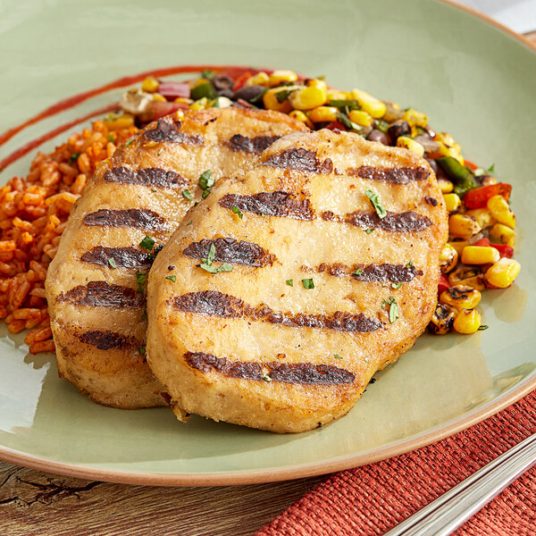 A white plate with Dr. Praeger's Plant-Based Vegan Chickenless Breasts, rice, and vegetables.