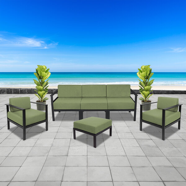 A BFM Seating Belmar outdoor patio set with black frames and green cushions.