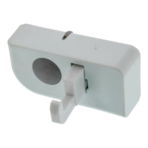 A white plastic lid lock catch with a grey circle.