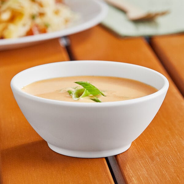 A World Centric white portion cup filled with soup on a table.