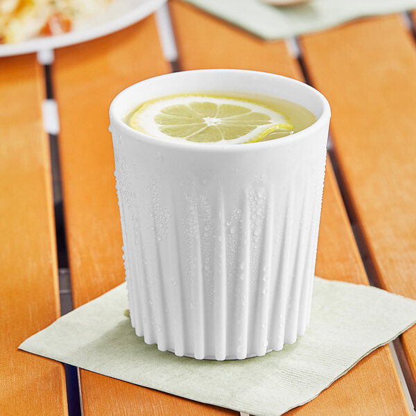 A World Centric white PLA cup with a slice of lemon in it.