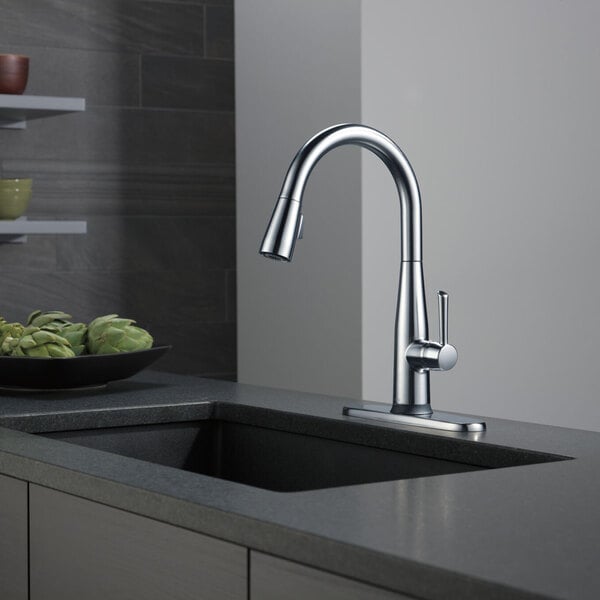 A Delta Essa kitchen faucet with an arctic stainless finish on a counter.
