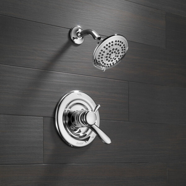 A Delta Lahara T-Series shower faucet and valve with a faucet knob on a wall.