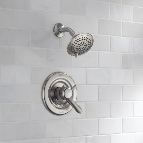 A stainless steel Delta Lahara shower and faucet trim kit with a shower head.