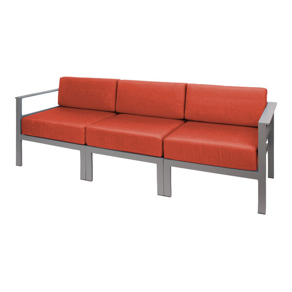 A BFM Seating outdoor sofa with a gray frame and orange cushions.