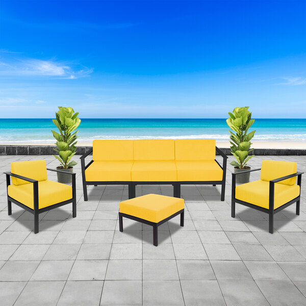 A BFM Seating Belmar yellow cushion on a black metal outdoor sofa.