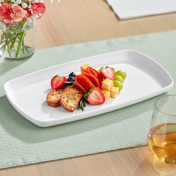 An American Metalcraft white melamine rectangle platter with fruit and cheese on it.