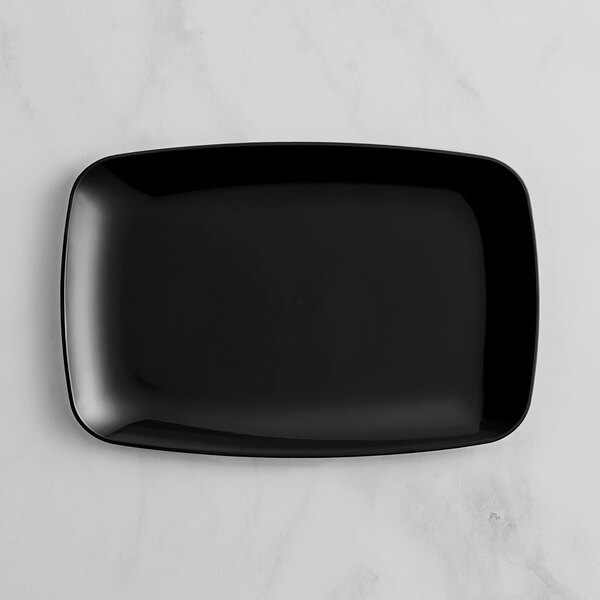 A black rectangular plastic Visions coupe platter on a marble surface.