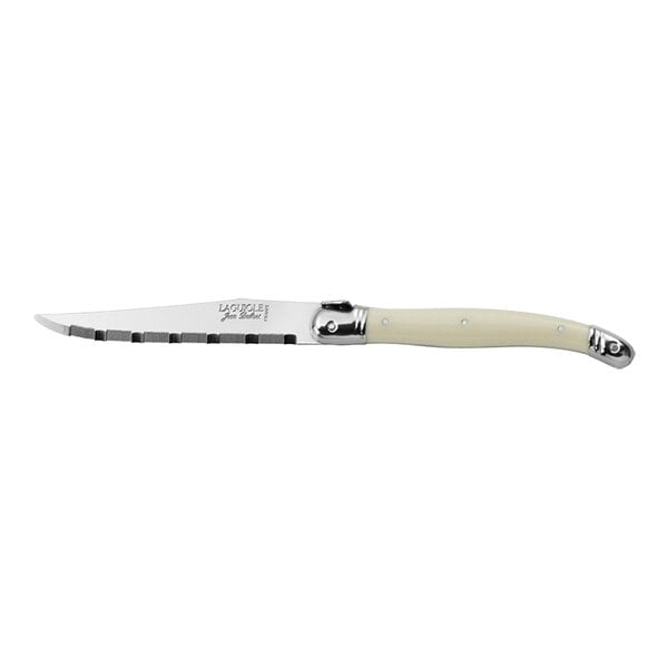 A Jean Dubost Laguiole stainless steel knife with an ivory handle and serrated blade.