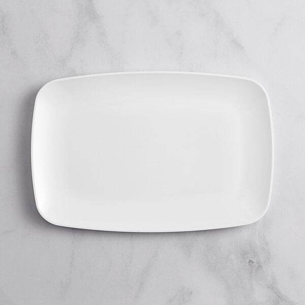 A white rectangular Visions plastic platter on a marble surface.