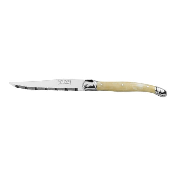 A Jean Dubost Laguiole stainless steel serrated steak knife with a white ABS handle with metal accents.