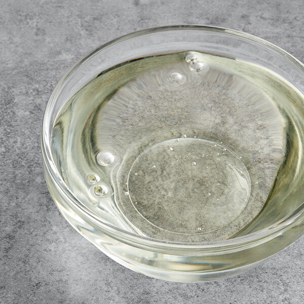 A clear bowl of clear liquid with bubbles in it.