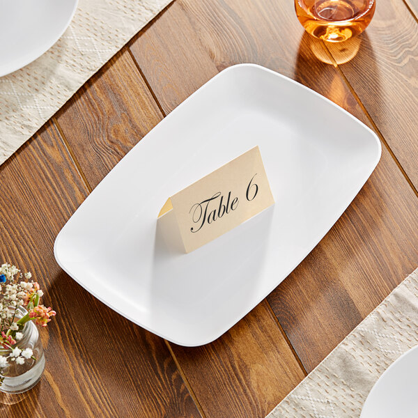A Visions white rectangular plastic coupe platter with a place card on it.