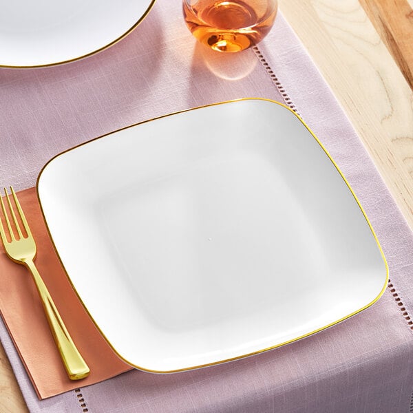 A Visions white square plastic plate with gold trim.