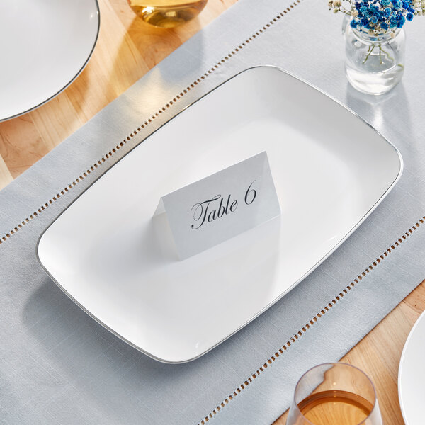 A white rectangular plastic Visions platter with a silver band on it.