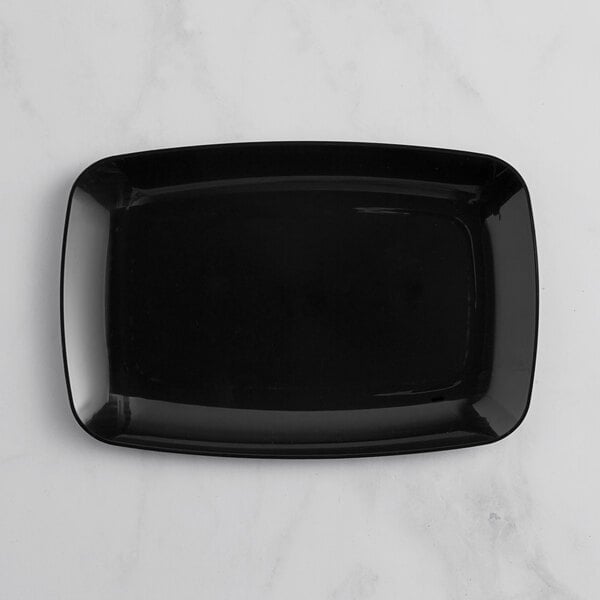A black rectangular Visions plastic serving tray on a white marble surface.