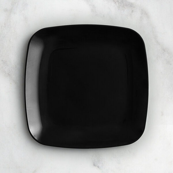 A black square Visions plastic coupe plate on a white surface.